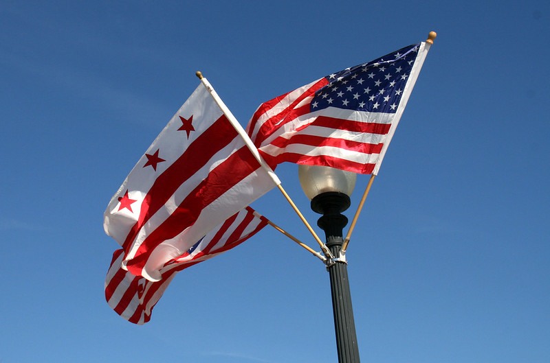 Photo of the US and DC flags on top of a light pole in Washington, DC
