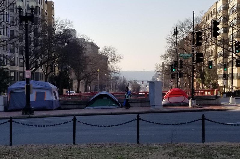 Photo of tents lined up on a DC street in between apartment buildings
