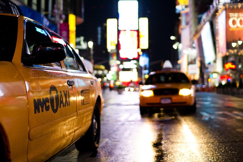 Photo of New York City taxi cabs driving now a dark, rain wettened street