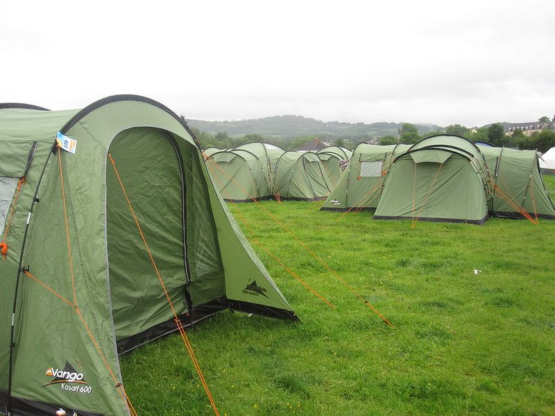 Photos of numerous identical tents set up in a field