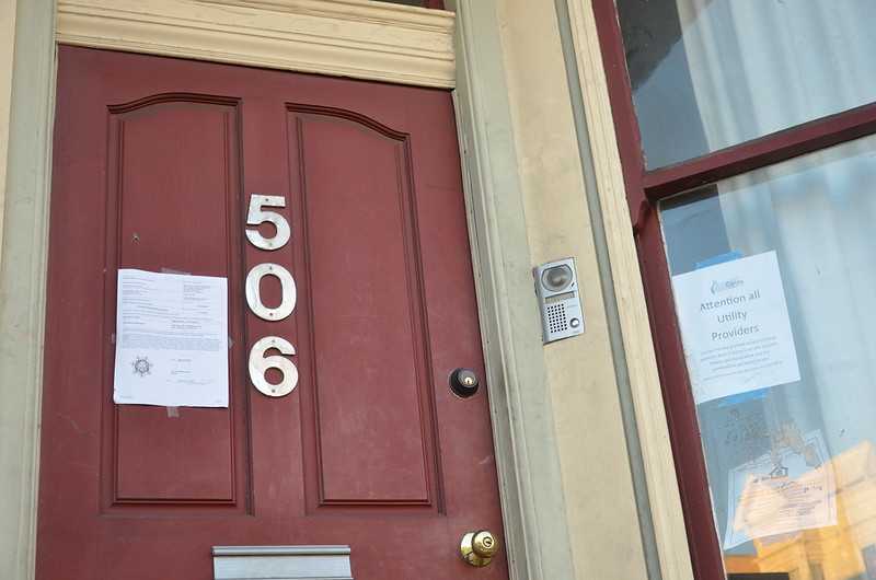 An eviction notice is pinned to a door in this photo