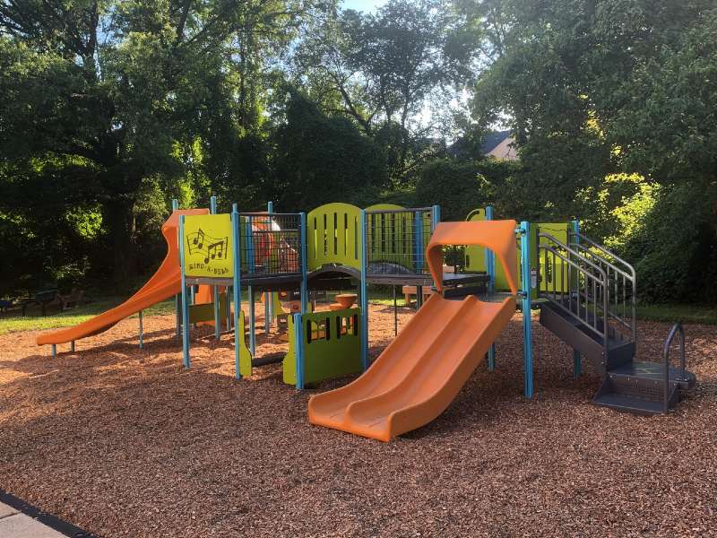 A colorful playground gym complete with multiple slides and climbing apparatuses