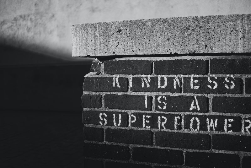 Photo of a brick wall with the phrase, "Kindness is a Superpower" stenciled on in paint