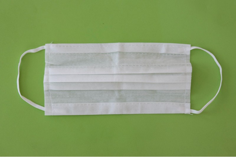 Photo of a disposable face mask against a green background