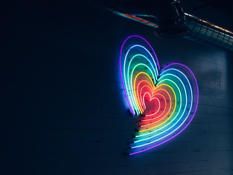 Photo of a neon wall sign consisting on numerous hearts in various colors