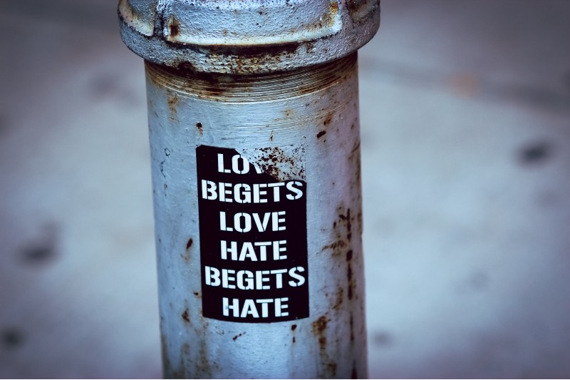 Photo of a sticker that reads, "Love begets love, hate begets hate"