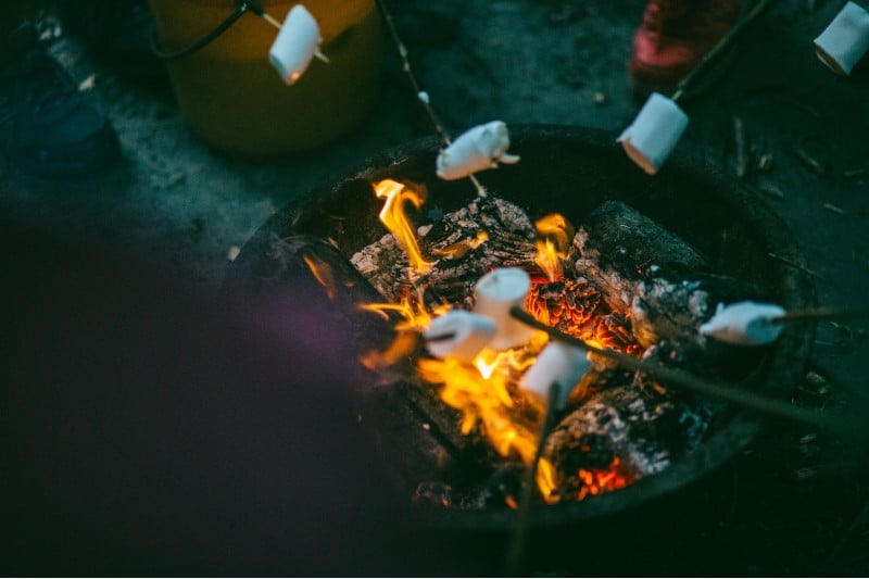 Photo of campers roasting marshmallows over a fire