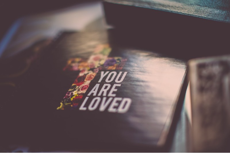 Photo of the cover of a book with a cross and the phrase "you are loved"