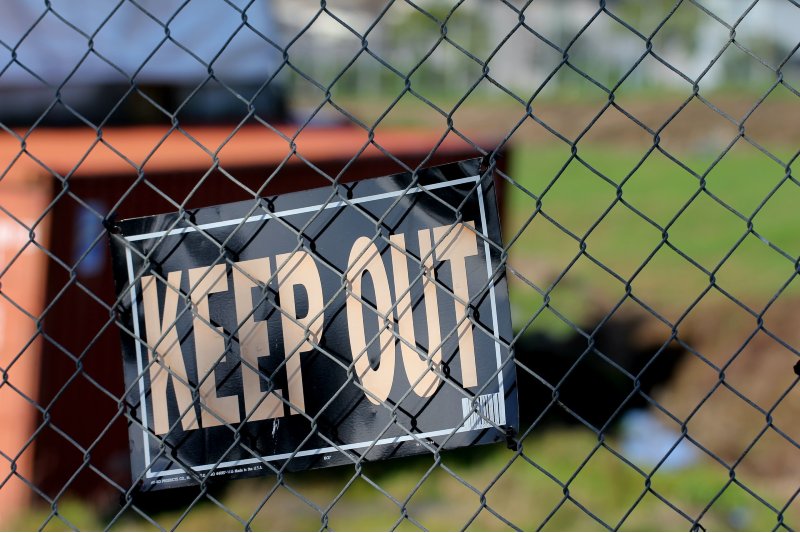 Photo of a Keep Out sign strapped to a fence