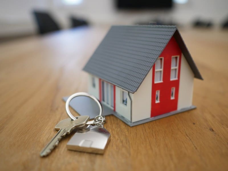 Photo of a set of house key next to a small model home