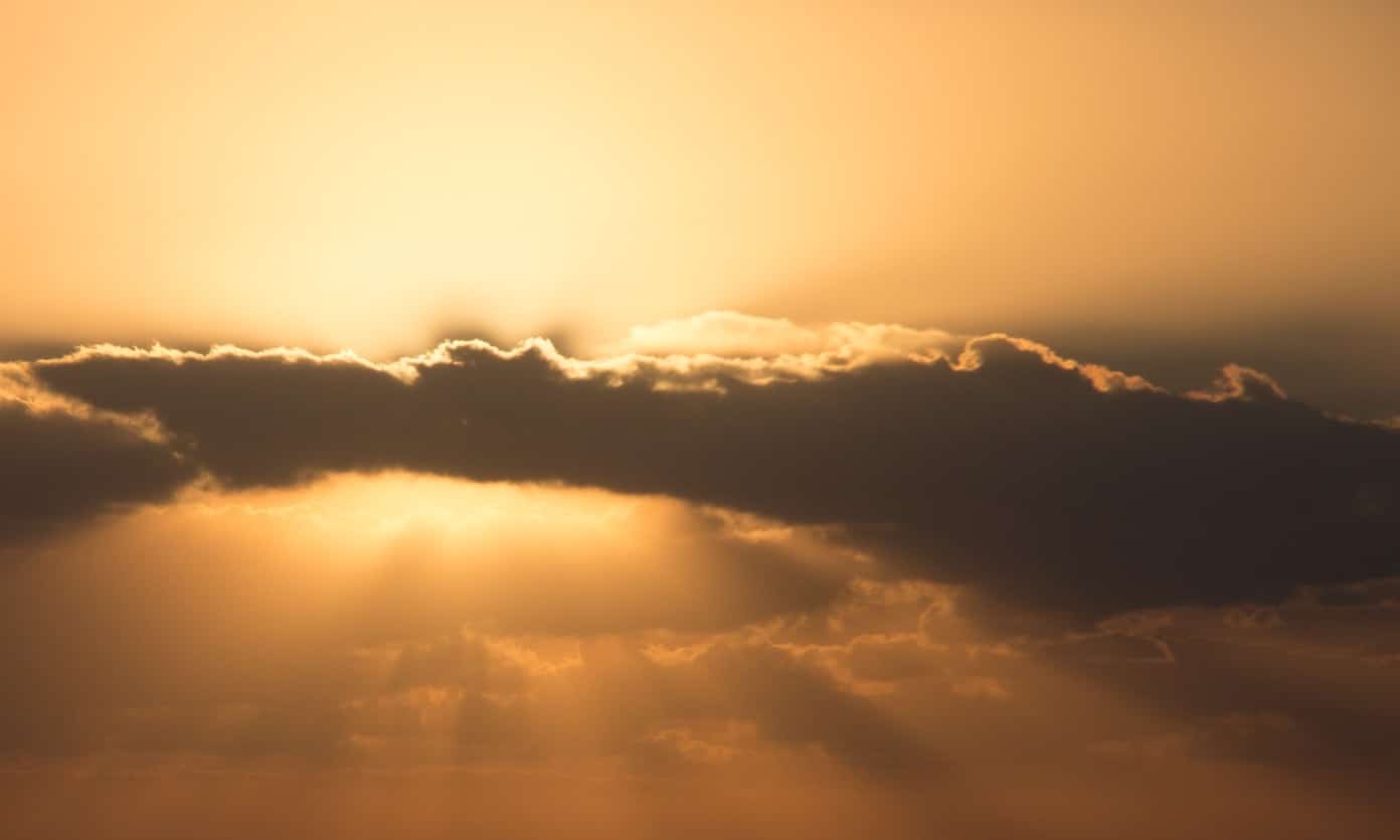 Photo of sun breaking out from behind clouds.