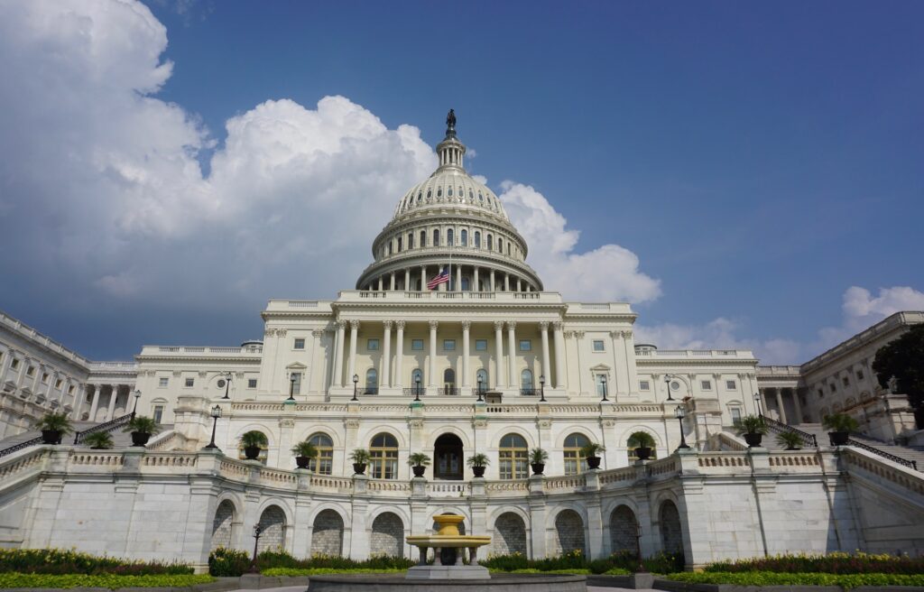 Photo of the U.S. Capitol building seen at a dramatic angle, towering over the viewer.