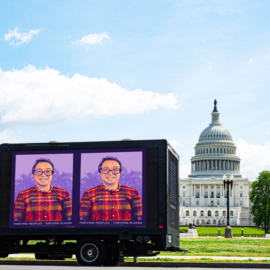 A portrait of indigenous Filipina activist Vicky Tauli-Corpuz is displayed on the side of a black truck in front of the U.S. Capitol.