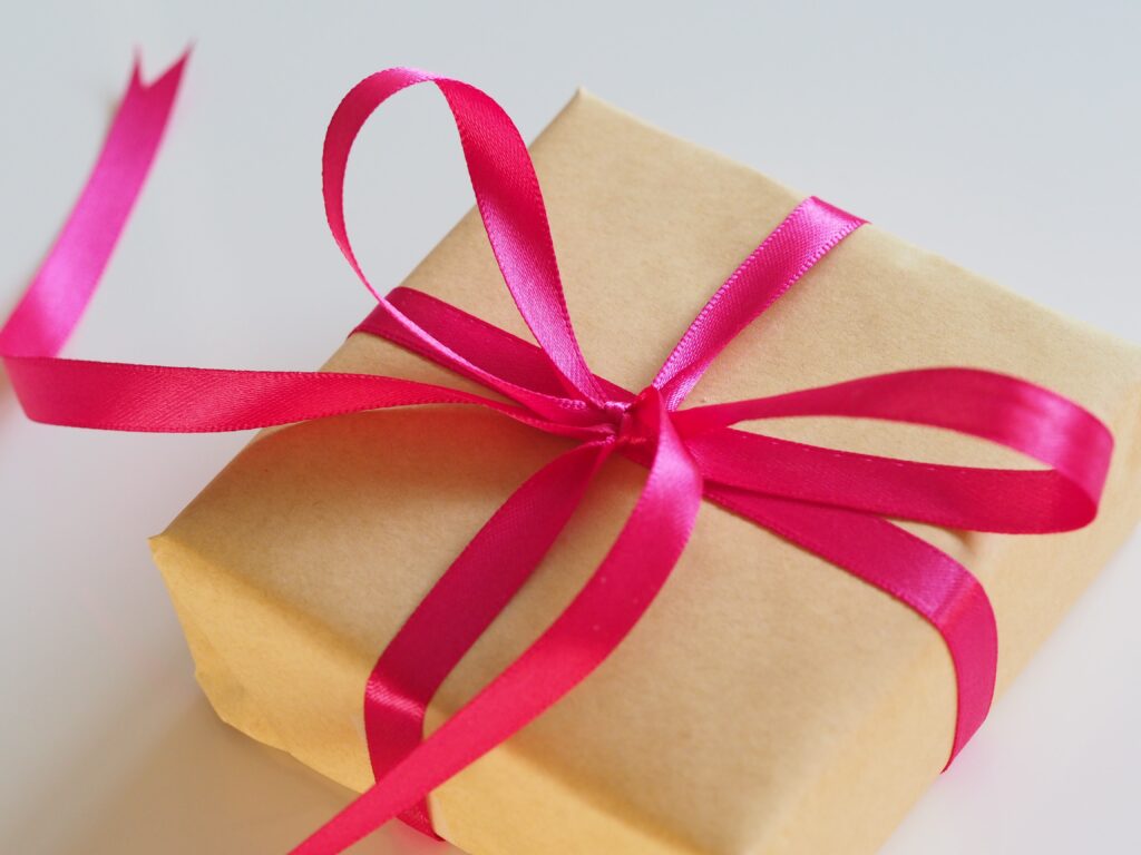 Photo of a box wrapped in brown paper with a pink bow.