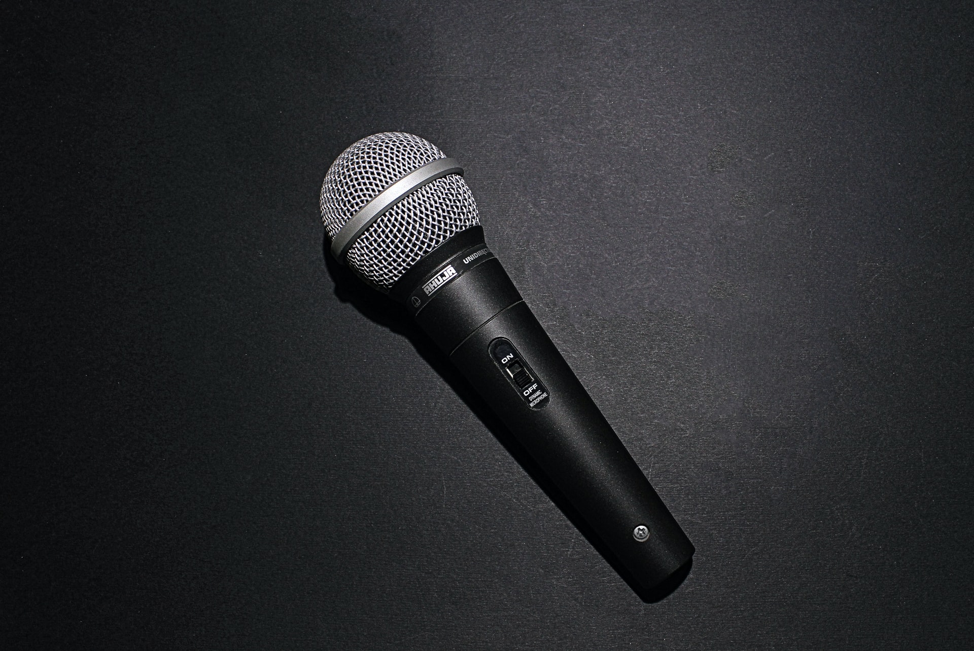 A photo of a microphone laying on a black surface.