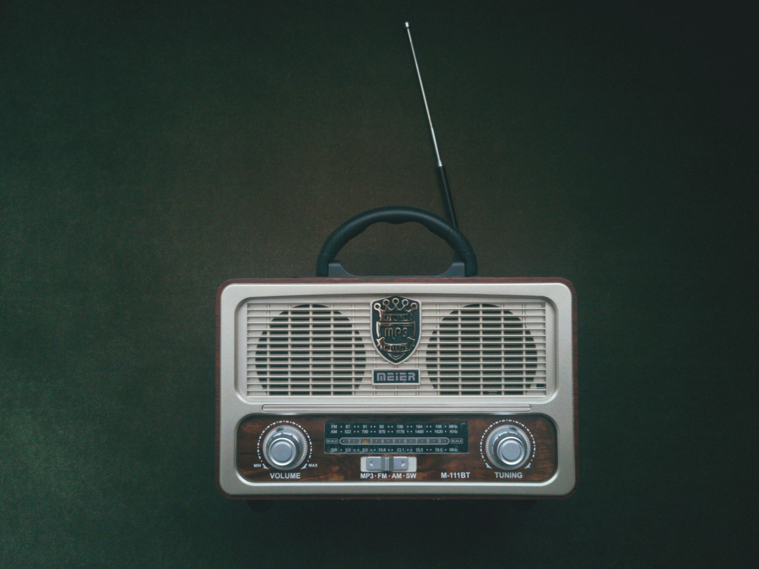 Photo of a portable radio with antenna against a grey backdrop.