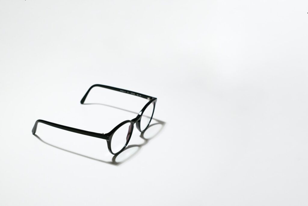 A photo of a pair of glasses sitting against a white reflective backdrop.