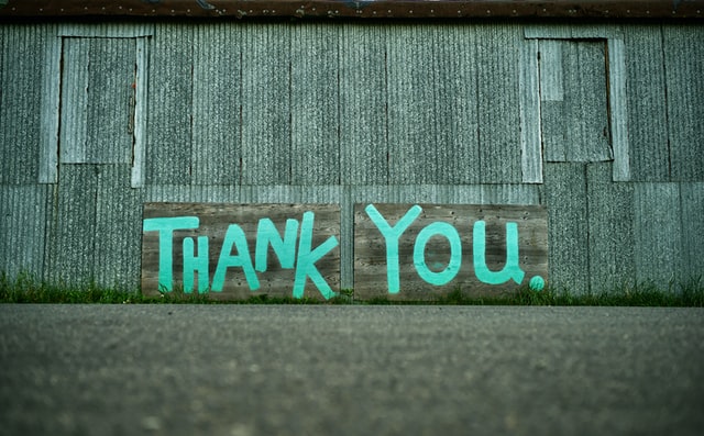 Photo of metal sided building with Thank You painted on.