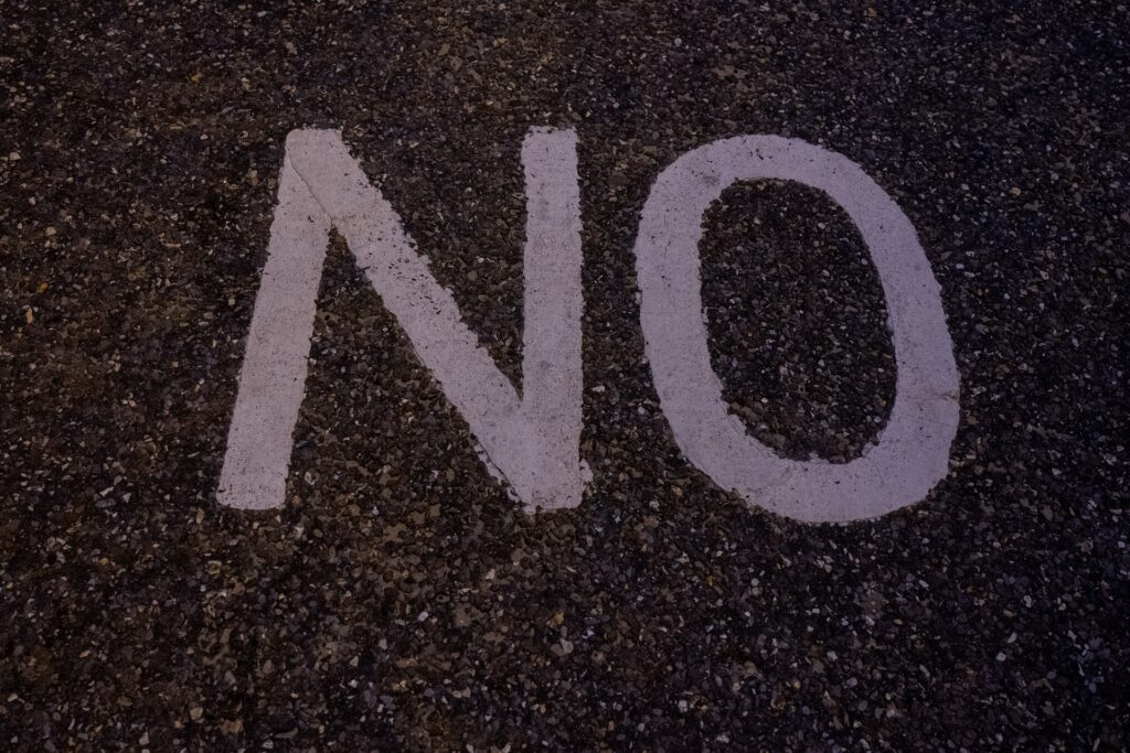 Photo of the word, "No" painted on the ground.