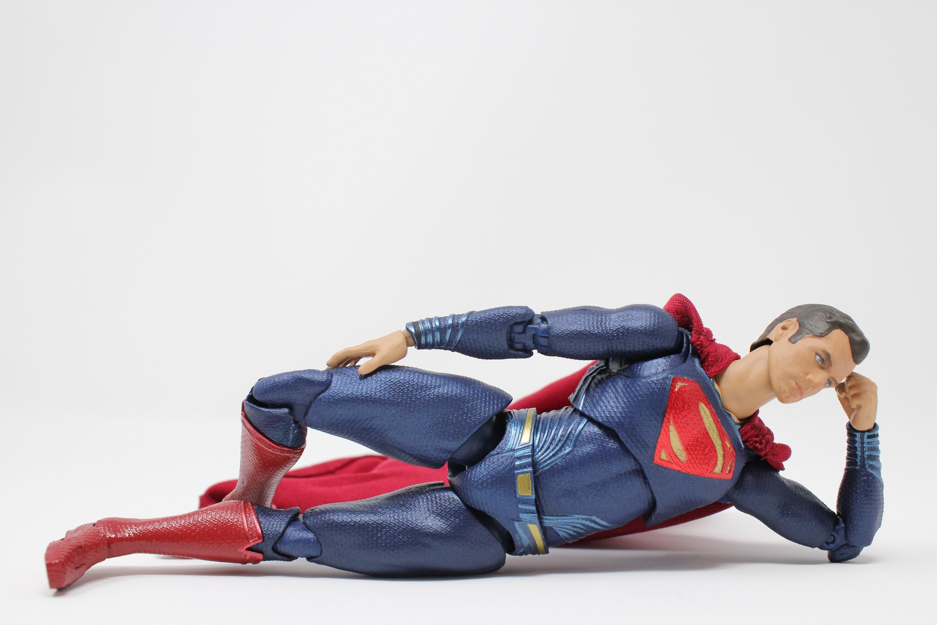 A photo of a Superman figure lying down against a white background.