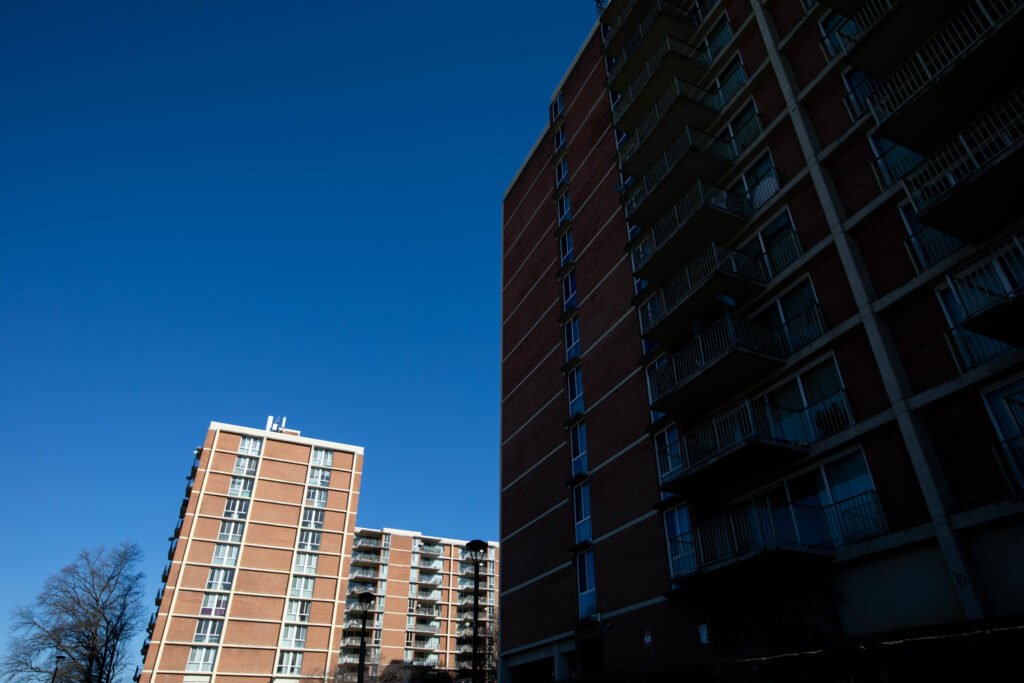 Two buildings stand against a blue sky.