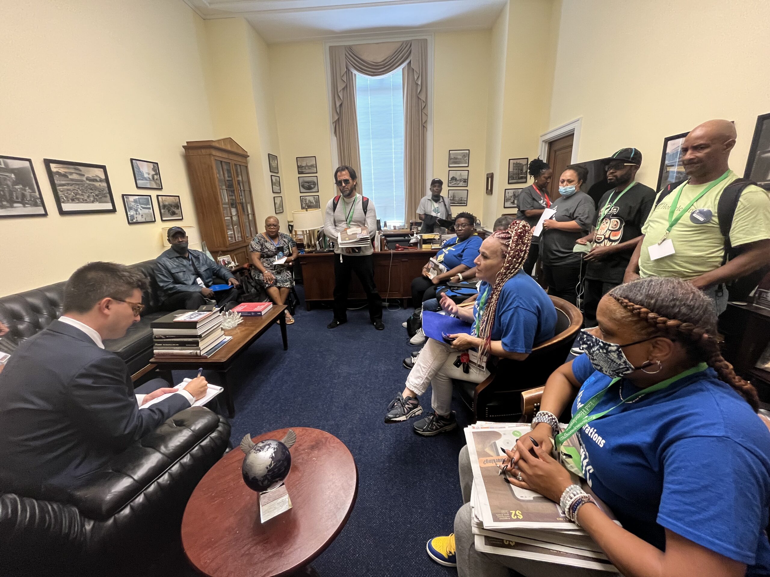 A dozen people sit an a Congressional office.