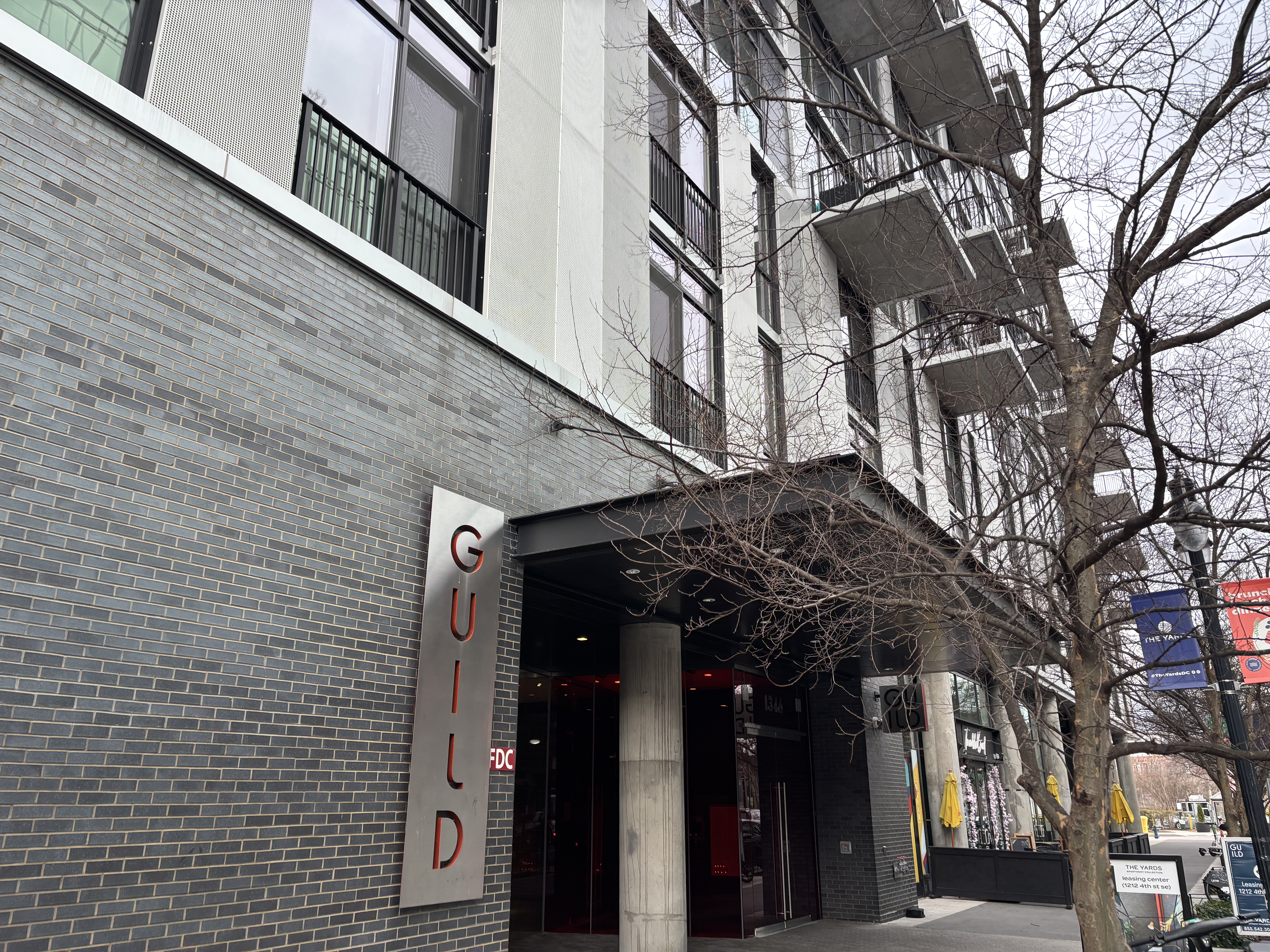 A grey apartment building with a sign reading "GUILD" in red letters.