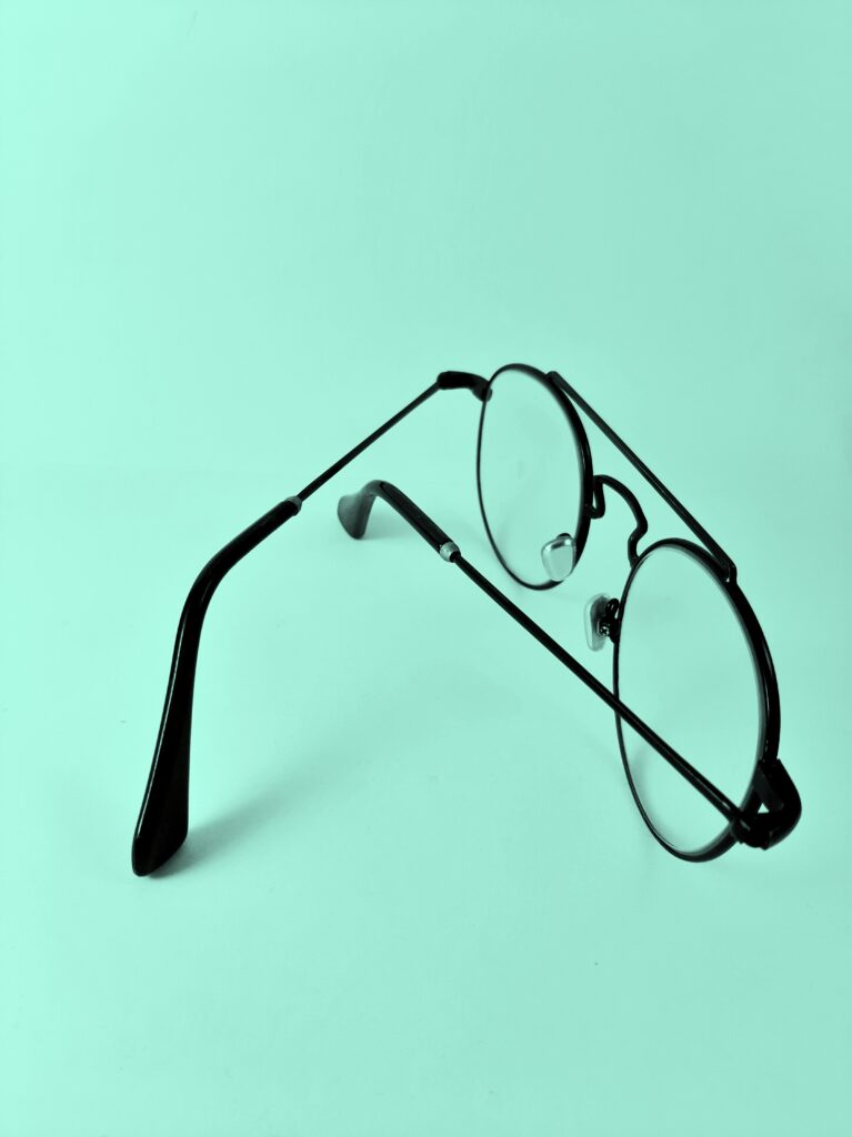 A pair of glasses on a teal background